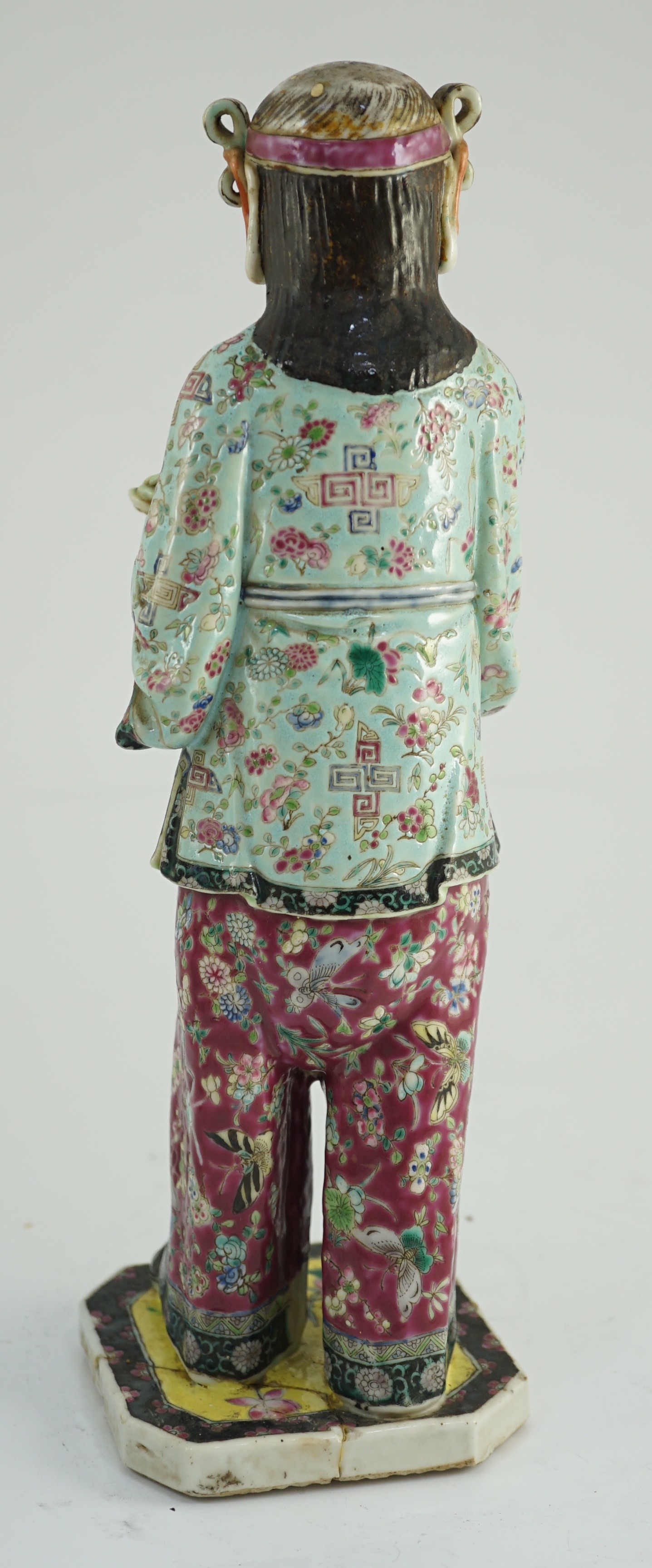 A Chinese enamelled porcelain figure of a boy attendant, early 20th century, 30.5cm high, base broken and re-glued